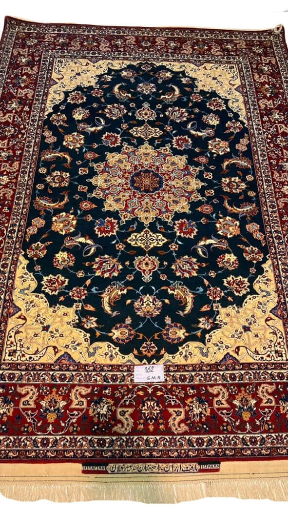 "Vintage hand-knotted Isfahan rug with a green field, yellow corners, and red borders by Ahmad Seirafian."